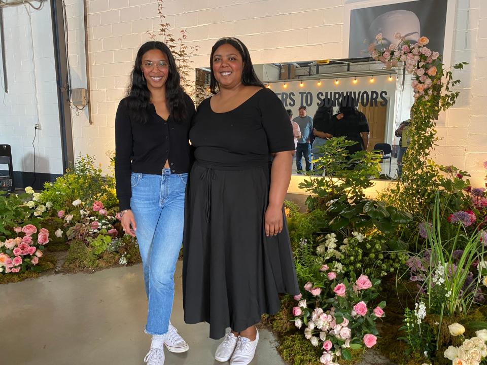 Artists and sisters Callie, left, and Lauren Palmer are seen recently during their studio's installation of Send Flowers to Survivors.