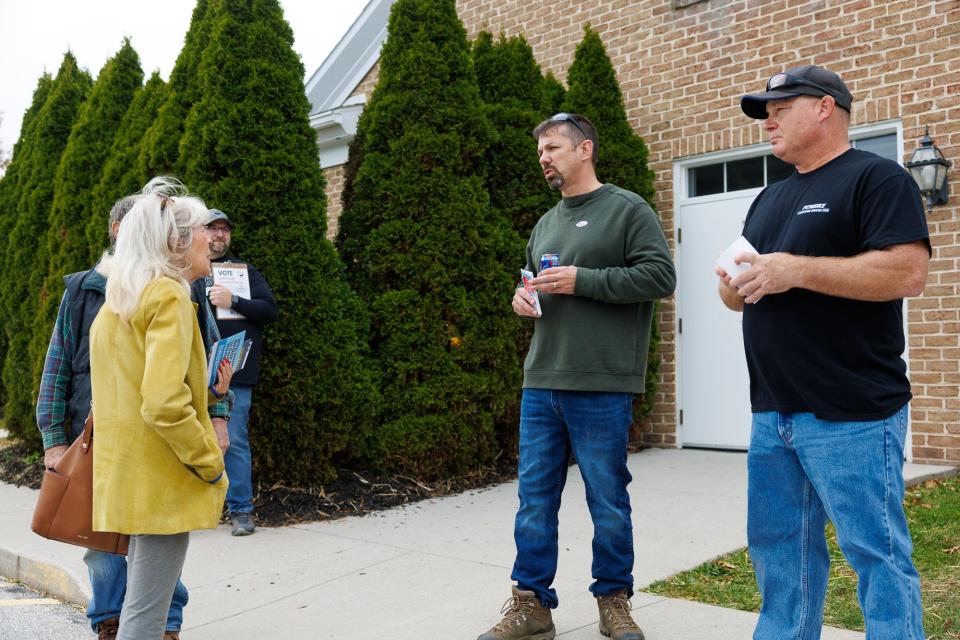 Matthew Gelazela, second from right, and Keith Gelsinger, right, speak with a voter outside of a polling place at Grace Global Methodist Church on election day, Tuesday, November 7, 2023, in Penn Township.