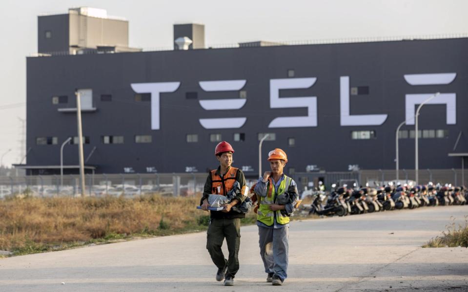 Workers walk outside the Tesla Inc. Gigafactory in Shanghai, China, on Friday, Nov. 1, 2019. - Bloomberg