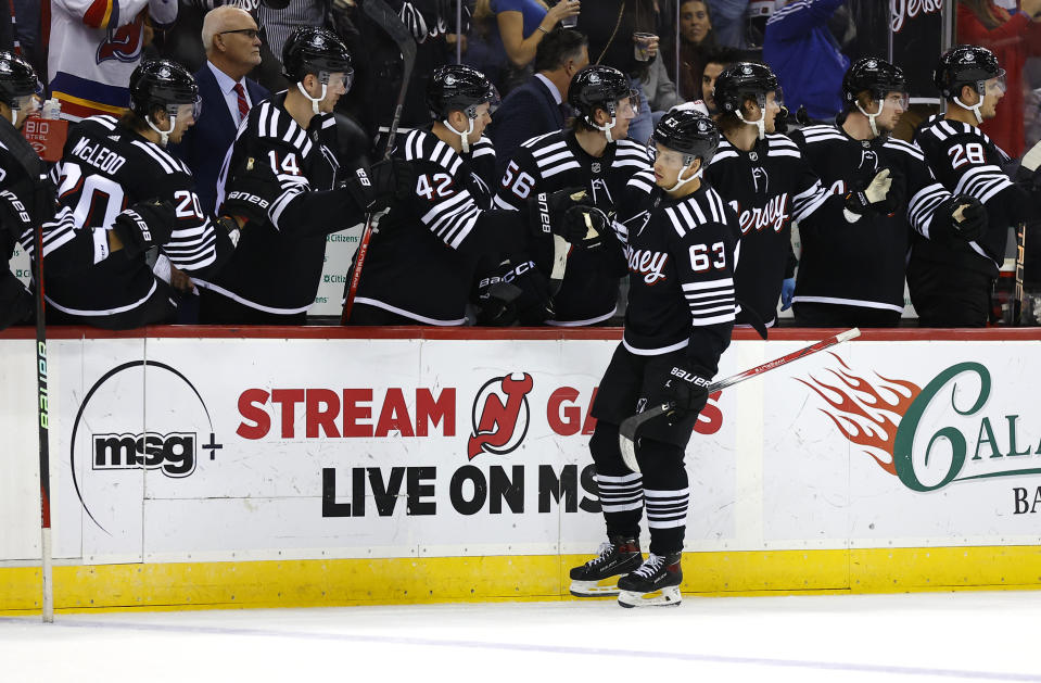 New Jersey Devils left wing Jesper Bratt (63) is congratulated after scoring a goal against the Buffalo Sabres during the first period of an NHL hockey game Friday, Oct. 27, 2023, in Newark, N.J. (AP Photo/Noah K. Murray)