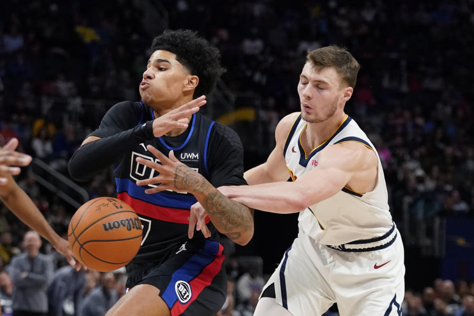 Denver Nuggets guard Christian Braun strips the ball away from Detroit Pistons guard Killian Hayes during the first half of an NBA basketball game, Monday, Nov. 20, 2023, in Detroit. (AP Photo/Carlos Osorio)