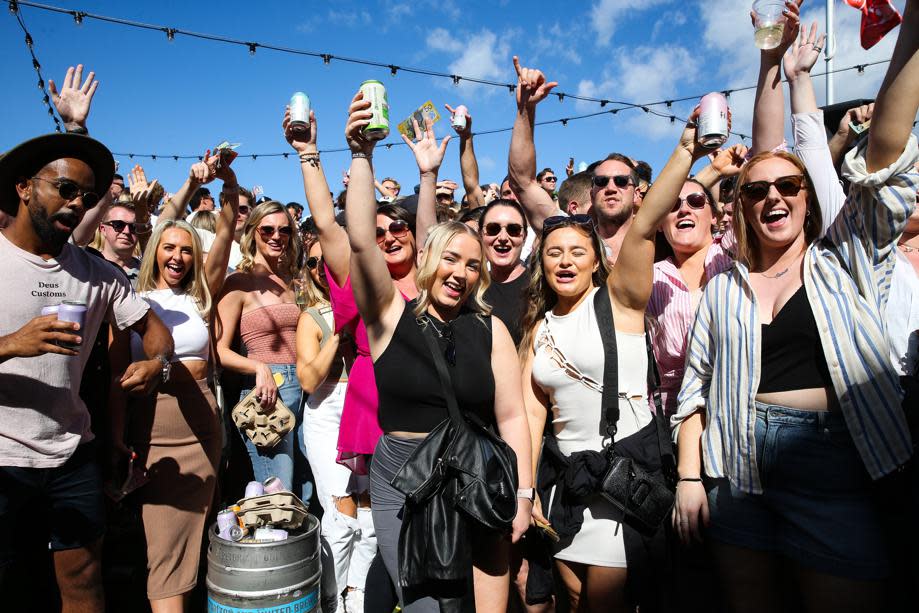 Crowd of people cheering at a Sydney pub. 