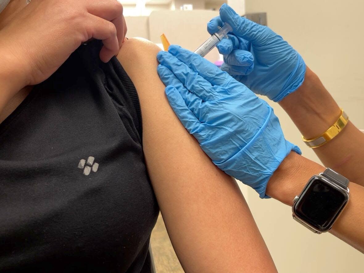 Pharmacist Shivali Sharma gives a flu shot at one of her Shoppers Drug Mart locations in Edmonton. (Emily Fitzpatrick/CBCNEWS - image credit)