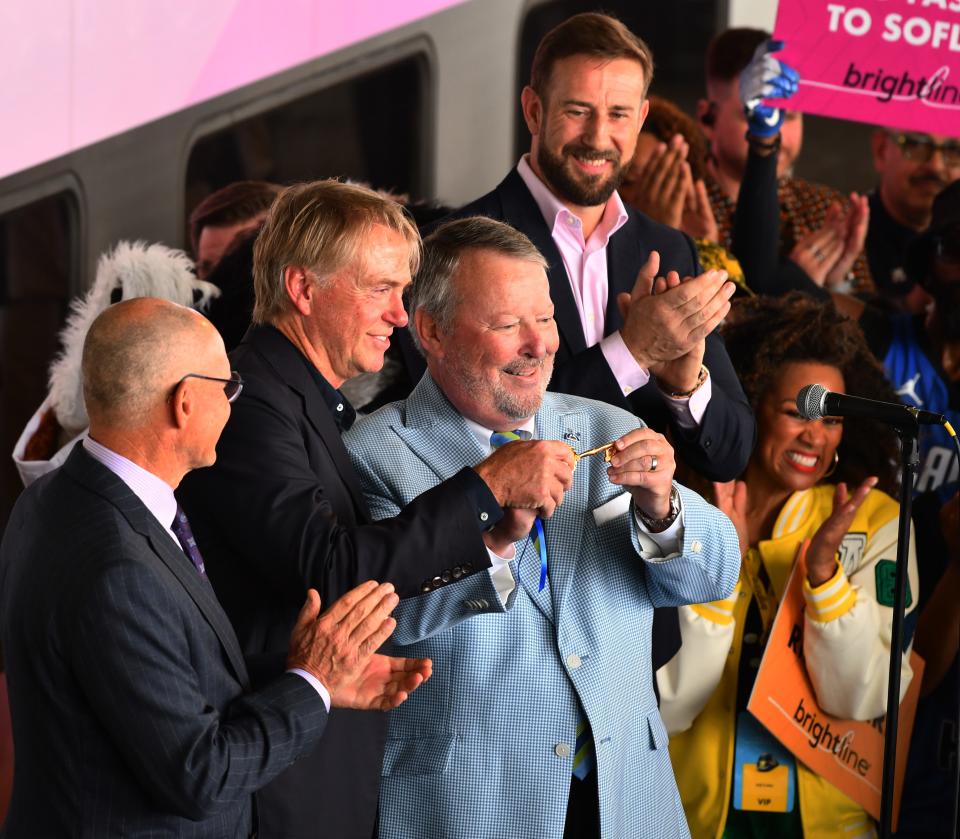 Mayor Buddy Dyer presents the key to the city to Brightline executives to celebrate the first brightline train arriving from Miami at the new statton in Orlando.