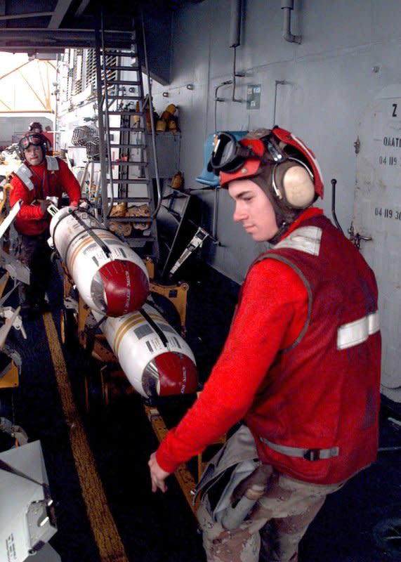 Airman David Rodriguez (R) prepares cluster bombs aboard the aircraft carrier USS Independence on February 12, 1998. On August 1, 2010, a worldwide ban on cluster bombs went into effect. File Photo by Felix Garza/U.S. Navy