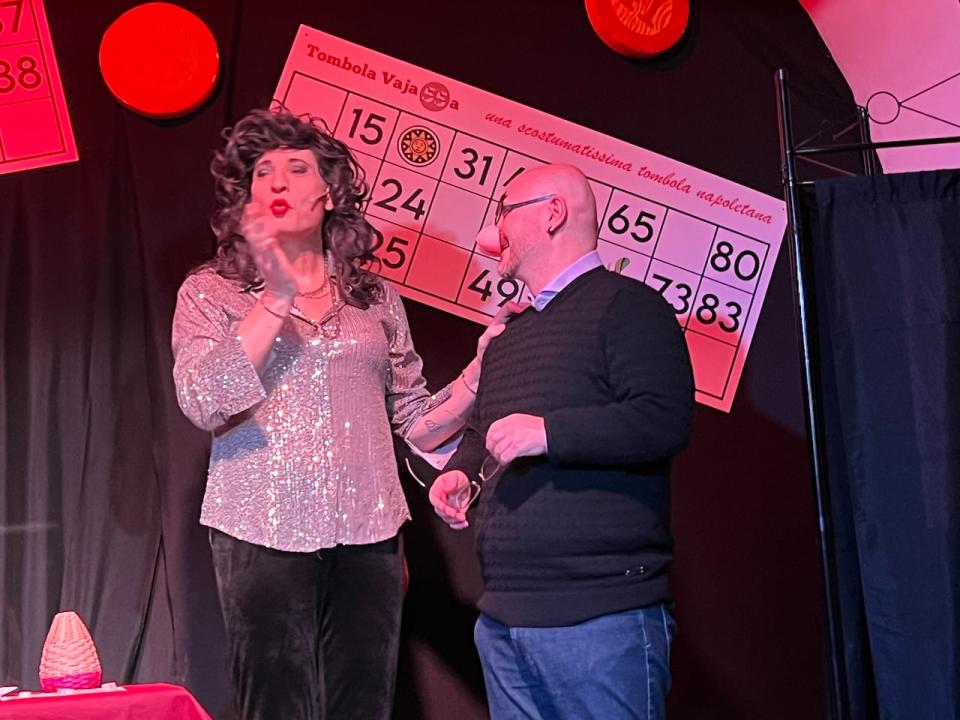 Lady Taboo hands out a prize for four in a row during a game of tombola at Tombola Vajassa in Naples, Italy.