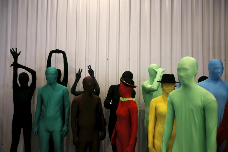 Participants wearing Zentai costumes take part in a march down the shopping district of Orchard Road during Zentai Art Festival in Singapore