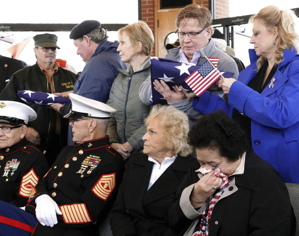 In this Jan. 17, 2019 photo, a flag is passed through a crowd of mourners as hundreds of people grieved three Memphis veterans, Wesley Russell, 76, Arnold Klechka, 71, Charles Fox, 60, who died this past fall and whose remains were unclaimed, in Memphis, Tenn. Funeral homes, medical examiners, state and federal veterans’ affairs departments, and local veterans’ groups have combined forces to honor members of the military whose bodies were not claimed by any relatives. (AP Photo/Karen Pulfer Focht)