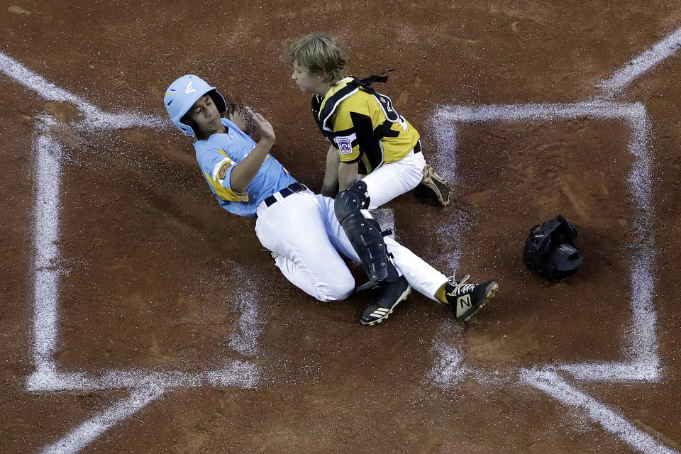 Wailuku, Hawaii's Nakea Kahalehau, left, scores under the tag by South Riding, Va.'s Noah Culpepper during the first inning of a baseball game at the Little League World Series in South Williamsport, Pa., Wednesday, Aug. 21, 2019. Hawaii won 12-9. (AP Photo/Gene J. Puskar)