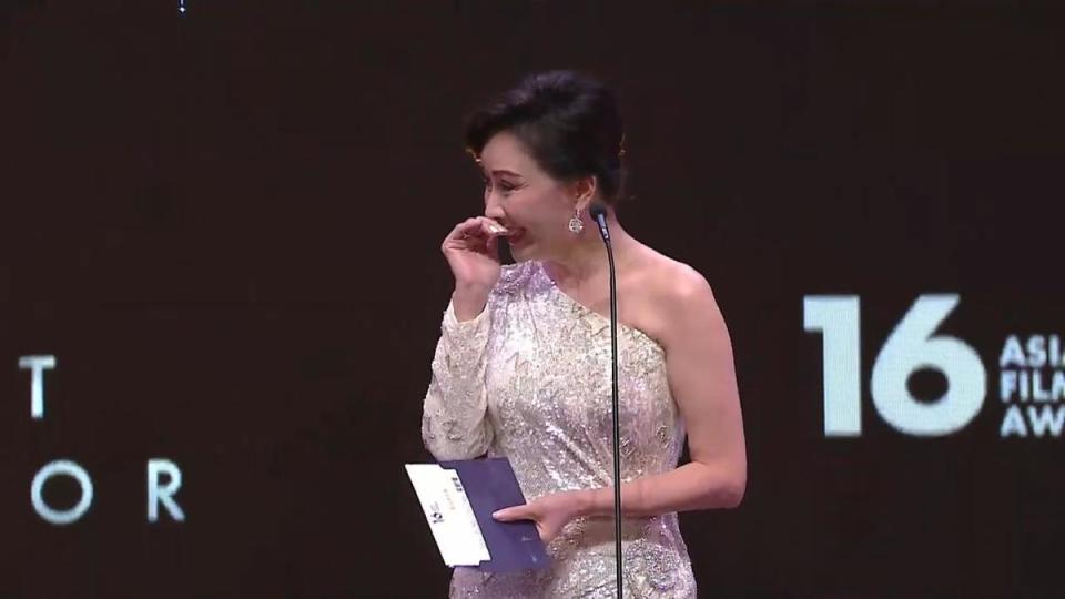劉嘉玲擔任最佳男主角頒獎人，看到信封裡的名字時忍不住露出害羞微笑。（翻攝自轉播畫面）