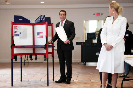 New York Governor Andrew Cuomo holds his ballot as his girlfriend Sandra Lee looks on (R) while voting in the New York Democratic primary election at the Presbyterian Church in Mt. Cisco, New York, U.S., September 13, 2018. REUTERS/Mike Segar