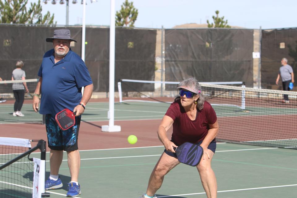 Ce Ce Sallee reaches for a volley attempt with her partner Robert David during a match at the Farmington Senior Olympic Pickleball Tournament, Saturday, April 9, 2022 at the Farmington Sports Complex.