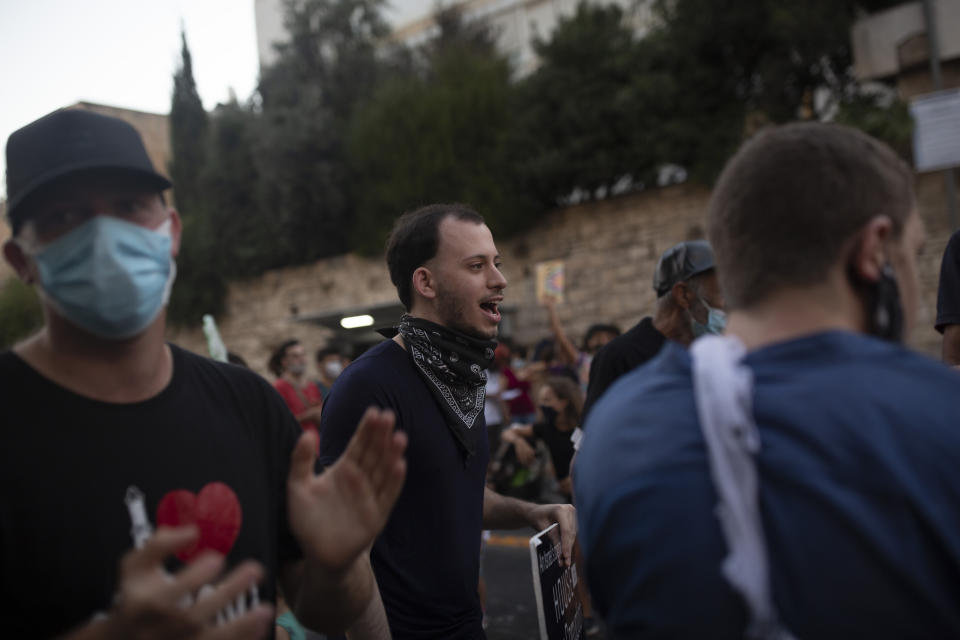 Shachar Oren, 25, chants slogans during a protest against Israel's Prime Minister Benjamin Netanyahu outside his residence in Jerusalem, Tuesday, Aug. 4, 2020. The boisterous rallies against Netanyahu have brought out a new breed of first-time protesters -- young, middle-class Israelis who have little history of political activity but feel that Netanyahu’s scandal-plagued rule and his handling of the coronavirus crisis have robbed them of their futures. (AP Photo/Maya Alleruzzo)