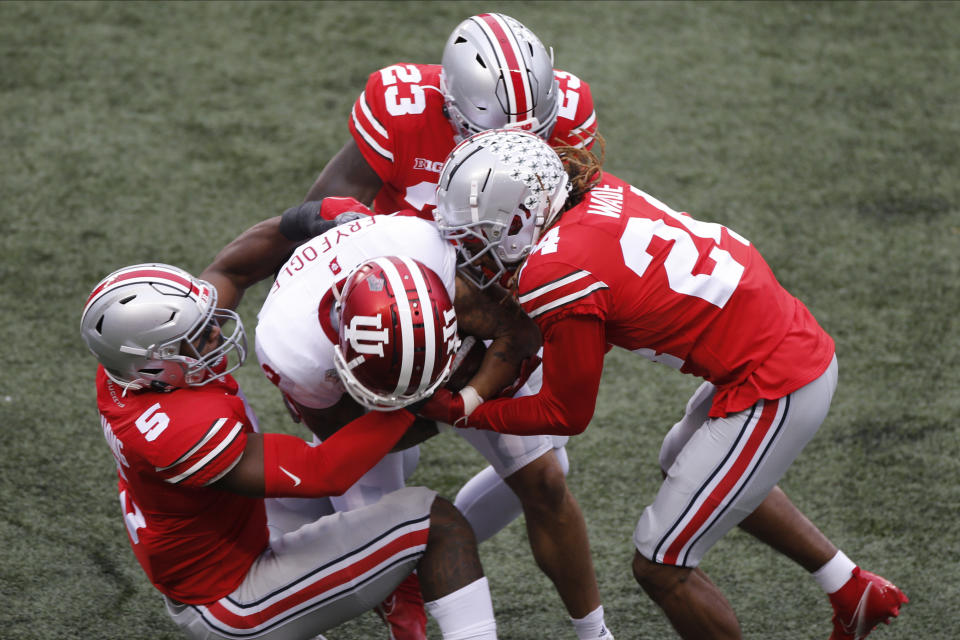 Ohio State defenders, left to right, Baron Browning, Marcus Hooker, and Shaun Wade tackle Indiana receiver Ty Fryfogle during the first half of an NCAA college football game Saturday, Nov. 21, 2020, in Columbus, Ohio. (AP Photo/Jay LaPrete)