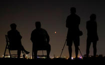 <p>People in a field watch a blood moon in the sky over the skyline of Frankfurt, Germany, July 27, 2018. (Photo: Kai Pfaffenbach/Reuters) </p>