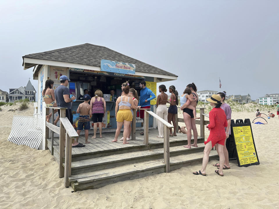 Beachgoers buy food and drinks at a concession stand on the beach at Ocean Grove, N.J., on Sunday, May 26, 2024. Beachgoers were out on the sand of one New Jersey shore community on a Sunday morning before Memorial day for the first time in generations amid a battle over a Christian religious group’s Sunday morning beach closures. (AP Photo/Tassanee Vejpongsa)