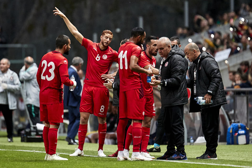 Tunisia players go to the sideline for mid-game nourishment during an injury delay against Portugal. (Getty)
