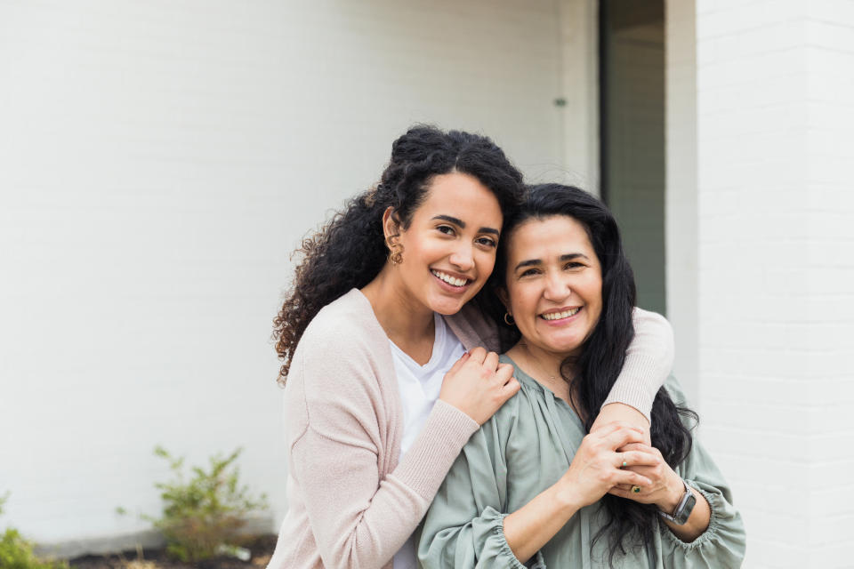 Two women embracing and smiling at the camera