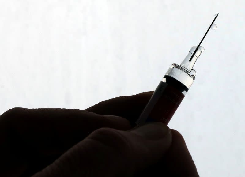 FILE PHOTO: A doctor prepares a syringe as part of the start of the seasonal influenza vaccination campaign in Nice