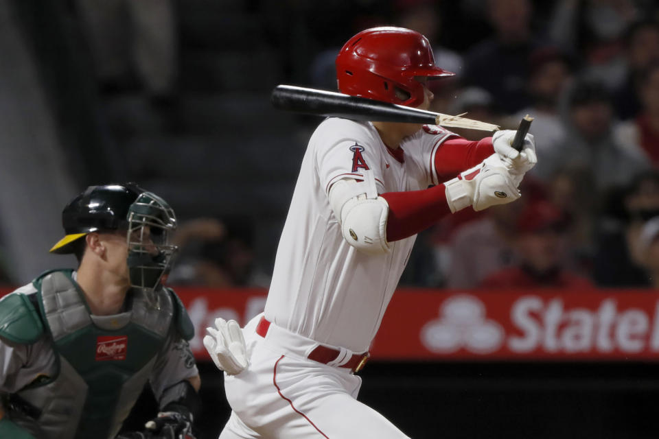 Los Angeles Angels designated hitter Shohei Ohtani hits a broken-bat single next to Oakland Athletics catcher Sean Murphy during the seventh inning of a baseball game in Anaheim, Calif., Saturday, Sept. 18, 2021. (AP Photo/Alex Gallardo)