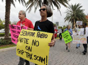 <p>Fred Frost, left, and Deborah Dion, right, protest against a Republican tax bill outside of the office of Sen. Marco Rubio, R-Fla., Monday, Nov. 27, 2017, in Doral, Fla. (Photo: Lynne Sladky/AP) </p>