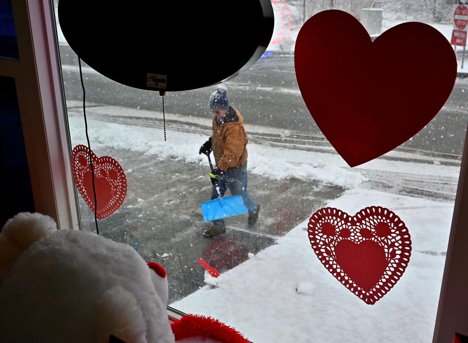 Brian Snay of Uxbridge, helping out a friend, shovels the parking lot at Springer Flowers at 1127 Millbury St. in Worcester on the day before Valentine's Day.
