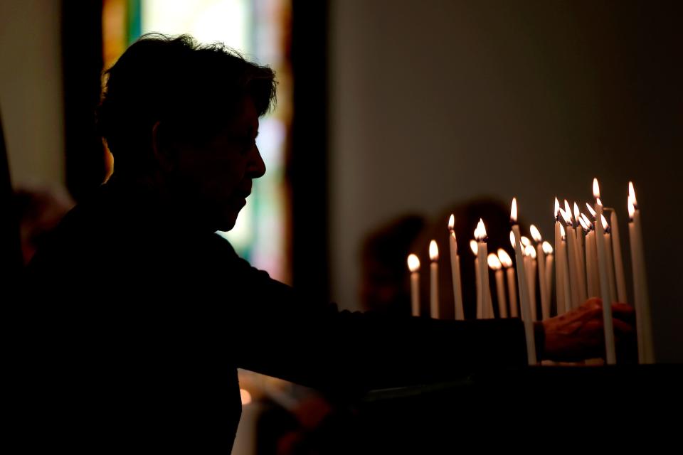 A woman places a candle on the altar during the Homeless Persons Memorial Service on Saturday at Eighth Street Church of the Nazarene, 701 NW 8 in Oklahoma City. 
(Photo: BRYAN TERRY/THE OKLAHOMAN)