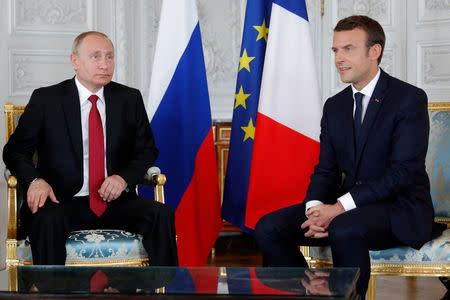 French President Emmanuel Macron (R) and Russian President Vladimir Putin (L) meet for talks at the Chateau de Versailles before the opening of an exhibition marking 300 years of diplomatic ties between the two counties in Versailles, France, May 29, 2017. REUTERS/Philippe Wojazer
