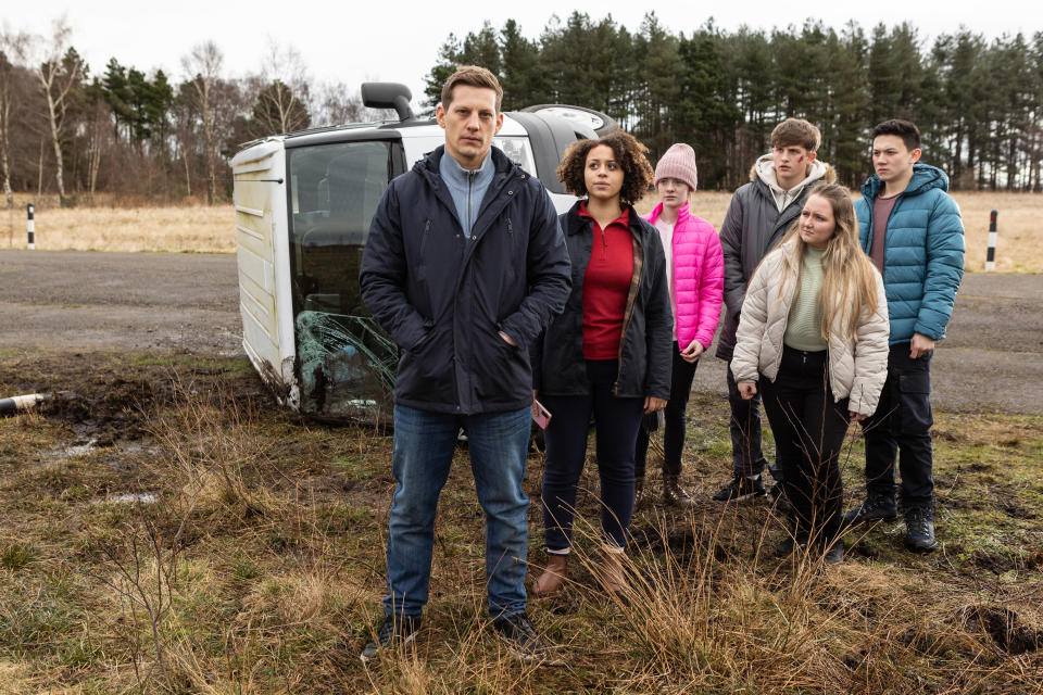 John Paul McQueen pictured next to the crashed minibus with his pupils.