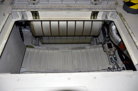 Aboard the space shuttle Endeavour, under the seats where astronauts sat for launch and landing, is a locker that held the lithium hydroxide (LiOH) canisters used to clean the orbiter's air of carbon dioxide. Lifting out that container offered