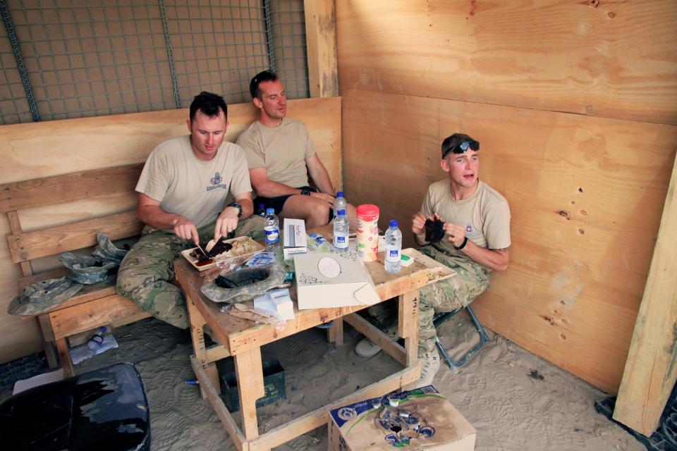 Then-Spc. William Yeske,center, eats a meal during a 2010 deployment to Afghanistan with then-Sgt. 1st Class Matthew Hill, right, and then-Sgt. Robert Musil, left.