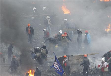 Anti-government protesters carry an injured man on a stretcher in Independence Square in Kiev February 20, 2014. REUTERS/Vasily Fedosenko