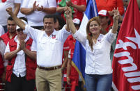 El candidato presidencial Hugo Martínez y su compañera de fórmula Karina Sosa, del Frente Farabundo Martí para la Liberación Nacional (FMLN), saludan a sus simpatizantes durante el cierre de campañas en San Salvador, El Salvador, el domingo 27 de enero de 2019. (AP Foto/Salvador Melendez)