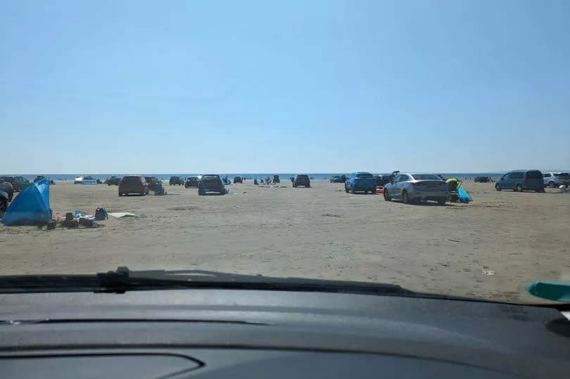 Cars and people on a beach