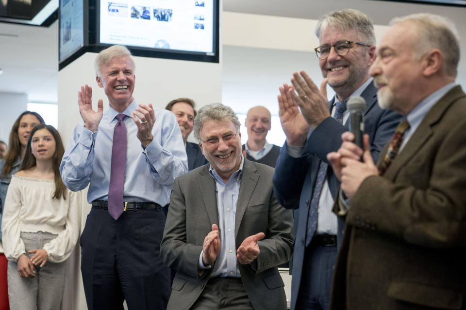 FILE - Washington Post Publisher Fred Ryan, foreground from left, Executive Editor Marty Baron, and National Security Editor Peter Finn, applaud as investigative reporter Tom Hamburger speaks to the newsroom after The Washington Post won two pulitzer prizes, on April 16, 2018, in Washington. Ryan is leaving the newspaper after nine years in charge. Newspaper owner Jeff Bezos announced Ryan’s departure in a memo to staff on Monday. He’ll continue as publisher and CEO for two more months. (AP Photo/Andrew Harnik, File)