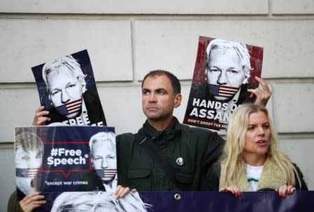 Demonstrators hold placards as they protest outside of Westminster Magistrates Court, where a case hearing for U.S. extradition of Wikileaks founder Julian Assange is held, in London