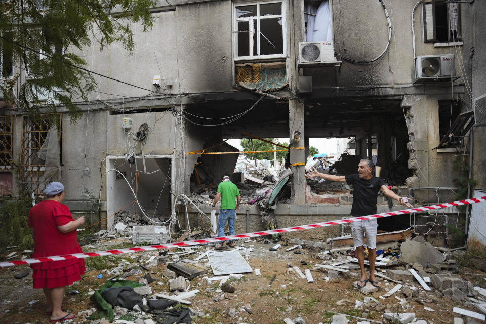 Israelis inspect a damaged residential building after it was hit by a rocket fired from the Gaza Strip, in Ashkelon, Israel, Monday, Oct. 9, 2023. (AP Photo/Erik Marmor)