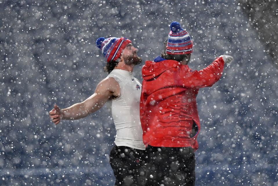 Buffalo Bills tight end Dawson Knox, left, warms up in the snow before an NFL football game against the New England Patriots in Orchard Park, N.Y., Monday, Dec. 6, 2021. (AP Photo/Adrian Kraus)