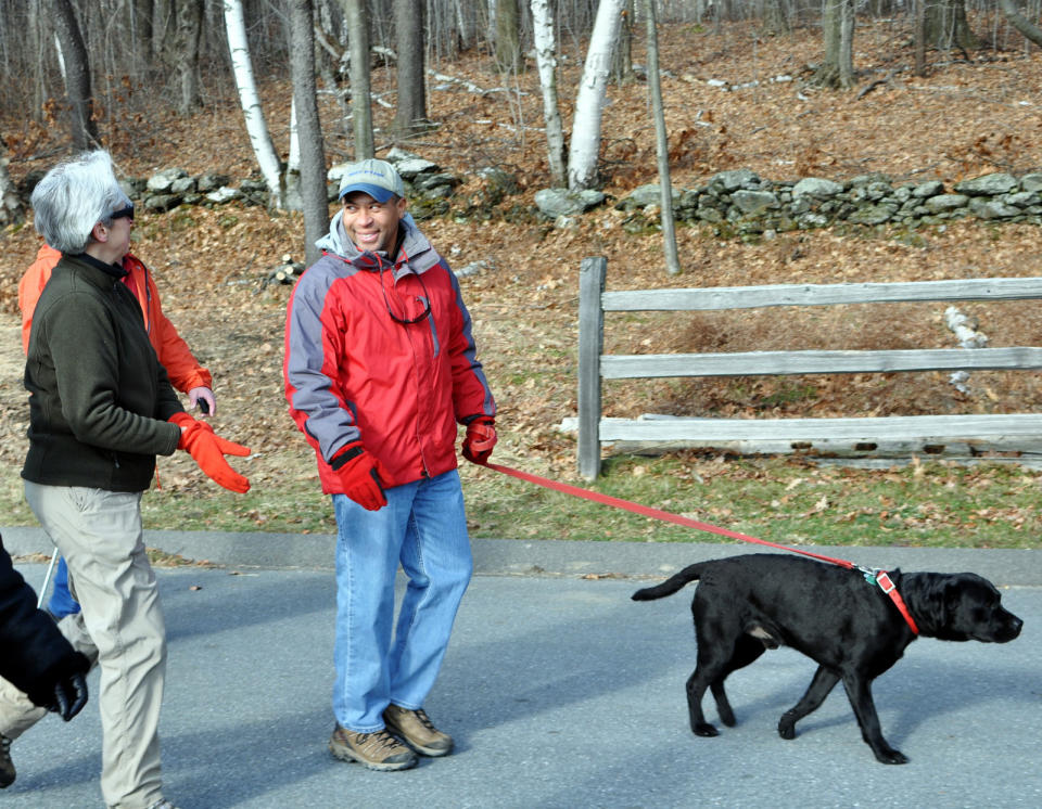 This Jan. 1, 2012 publicity image provided by Massachusetts State Department of Conservation and Recreation shows Gov. Patrick Deval and his dog Tobey, participating in a First Day hike at Mount Greylock State Reservation in Lanesborough, Mass. Massachusetts has organized hikes in state parks on New Year's Day for more than 20 years. An effort by a group called America's State Parks to expand the program last January succeeded in getting 14,000 people to take part in hikes in 400 parks in 50 states. This coming Jan. 1, the program is expected to be even bigger. (AP Photo/Tim Zelazo/ MassParks Department of Conservation and Recreation Staff)