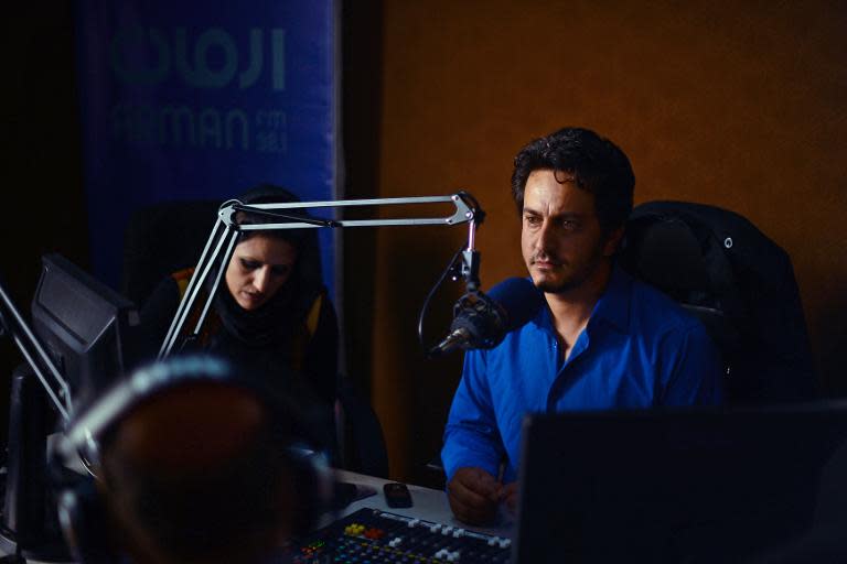 Afghan radio presenter Masood Sanjer (R) listens to a caller during the "Safai Shahar" (Cleaning the City) at Arman Radio in Kabul on June 10, 2014
