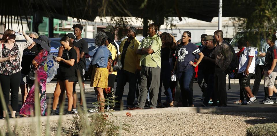 People line up to attend a community meeting, Tuesday, June 18, 2019, in Phoenix. The community meeting stems from reaction to a videotaped encounter that surfaced recently of Dravon Ames and his pregnant fiancee, Iesha Harper, having had guns aimed at them by Phoenix police during a response to a shoplifting report, as well as the issue of recent police-involved shootings in the community. (AP Photo/Ross D. Franklin)