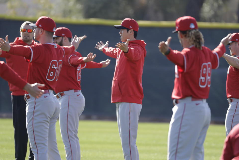 Los Angeles Angels' Shohei Ohtani stretches with teammates during spring training baseball practice, Wednesday, Feb. 12, 2020, in Tempe, Ariz. (AP Photo/Darron Cummings)