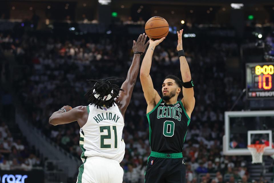 Jayson Tatum (0) shoots over Jrue Holiday during Game 4  at Fiserv Forum.