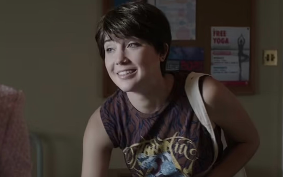 Smiling Gaia with short hair and a sleeveless T-shirt