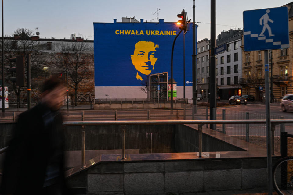 People walk past a recent painted mural featuring the President of Ukraine, Volodymyr Zelenskyy