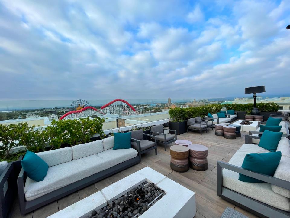 Rise rooftop with white furniture and view of disneyland coaster in background
