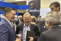 Berkshire Hathaway investment manager Ted Weschler, center, talks with Brooks Running CEO Dan Sheridan, Friday, May 3, 2024, in Omaha, Neb., one day ahead of the annual shareholders meeting. (AP Photo/Josh Funk)