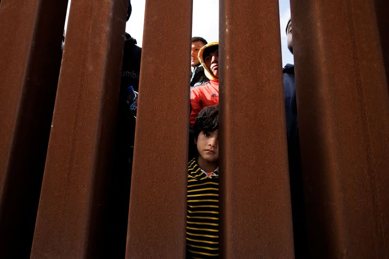 Migrants gather along the U.S. Mexico border near San Diego before the lifting of Tile 42