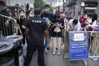 People scan health check codes with their smartphones to show to a security guard at a tourist shopping street in Beijing, Tuesday, Aug. 3, 2021. Chinese authorities announced Tuesday mass coronavirus testing in Wuhan as an unusually wide series of COVID-19 outbreaks reached the city where the disease was first detected in late 2019. The current outbreaks, while still in the hundreds of cases in total, have spread much more widely than previous ones, reaching multiple provinces and cities including the capital, Beijing. (AP Photo/Mark Schiefelbein)