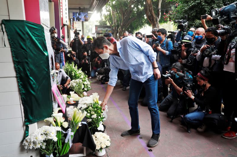 A member of the French community living in Mexico places flowers at an altar outside a restaurant owned by French businessman Baptiste Jacques Daniel Lormand after he was found murdered, in Mexico City